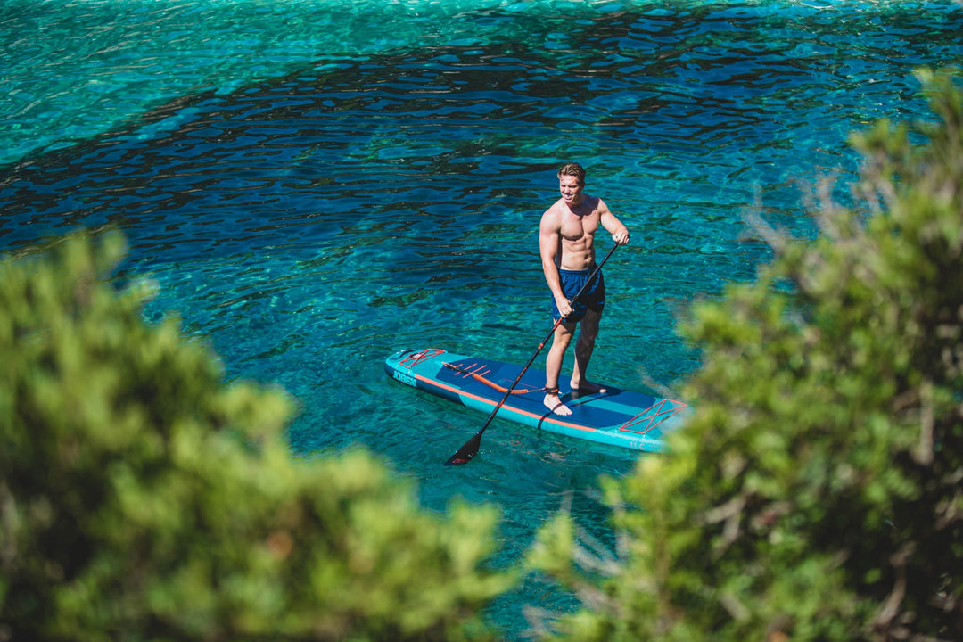 Man on SUP board in clear blue sea