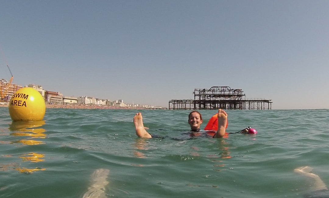 person floating on sea brighton west pier in background