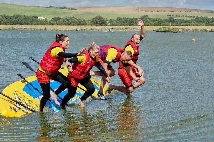 Adult group jumping off jumbo SUP board