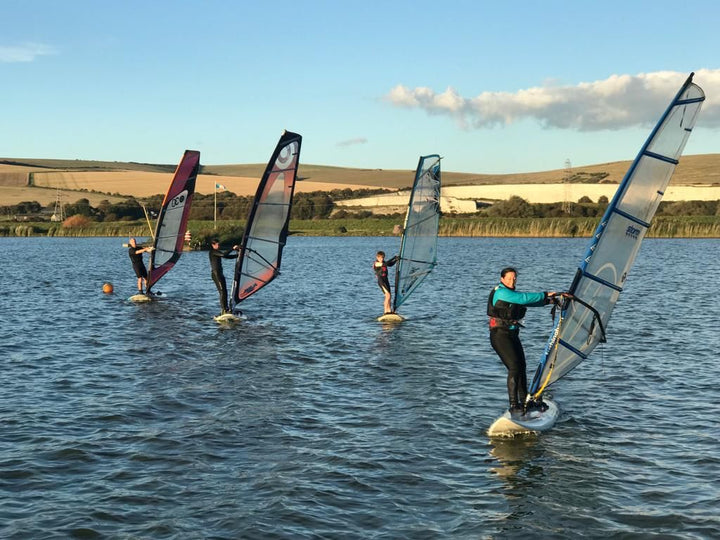 Group of 4 windsurfers on lake